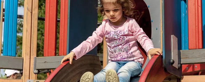 Mädchen rutscht eine Rutsche runter