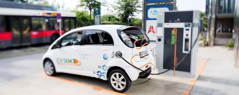 Weißer Kleinwagen an E-Tankstelle
