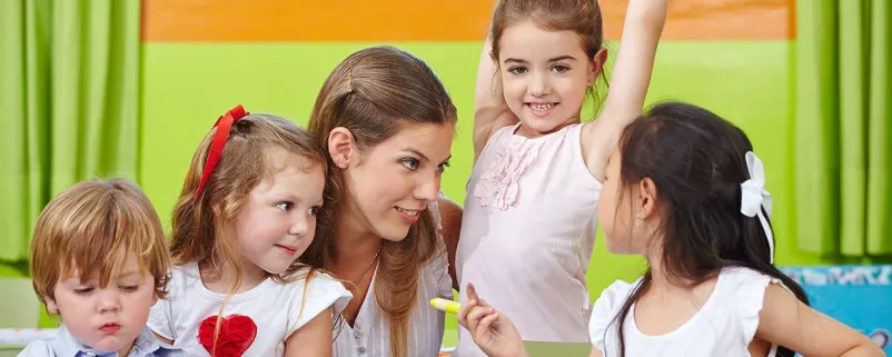 Kindergartentante spielt mit Kindergartenkindern