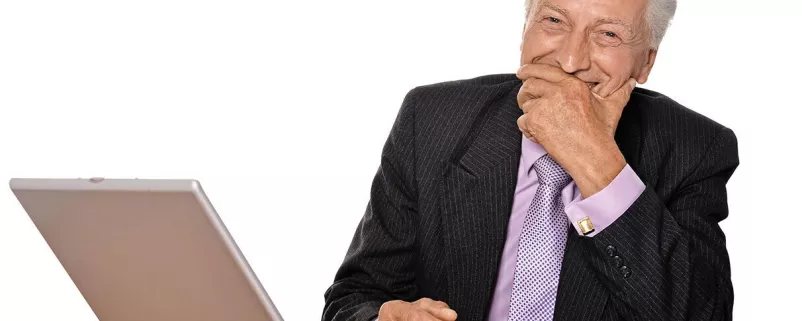 Amtsleiter lacht vor Laptop