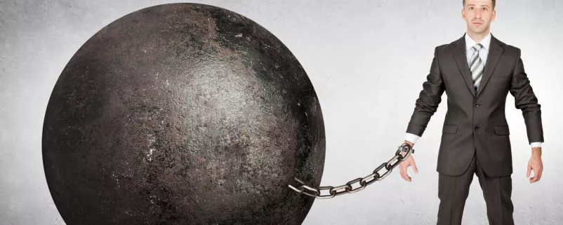 Mann an große Kugel gekettet