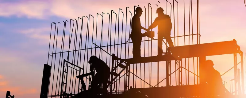 Baustelle und Bauarbeiter im Sonnenuntergang