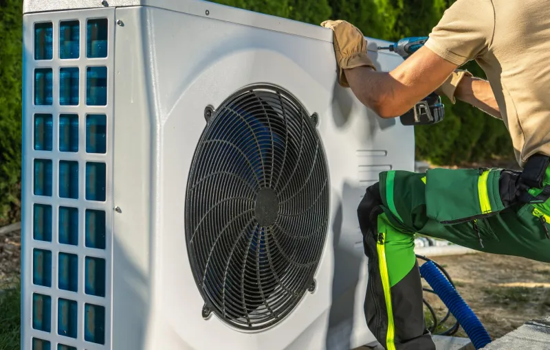 Mann montiert Wärmepumpe