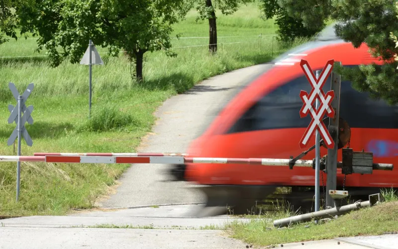 Zug fährt bei Bahnschranken vorbei