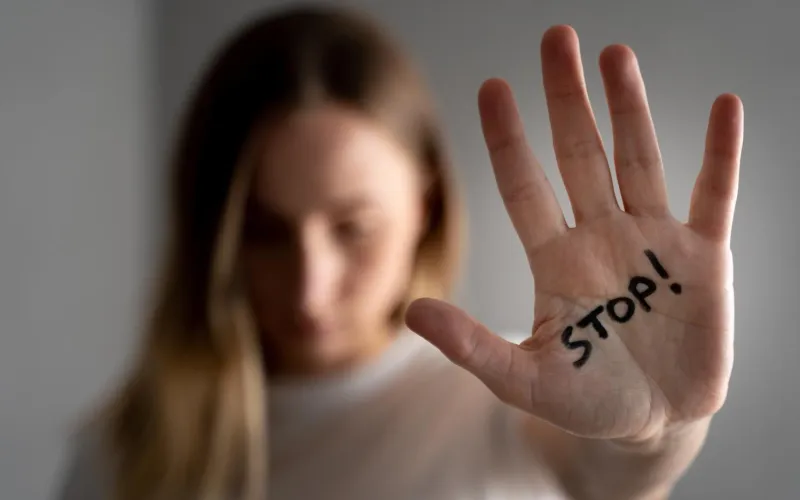 Frau zeigt Handfläche mit Aufschrift Stop