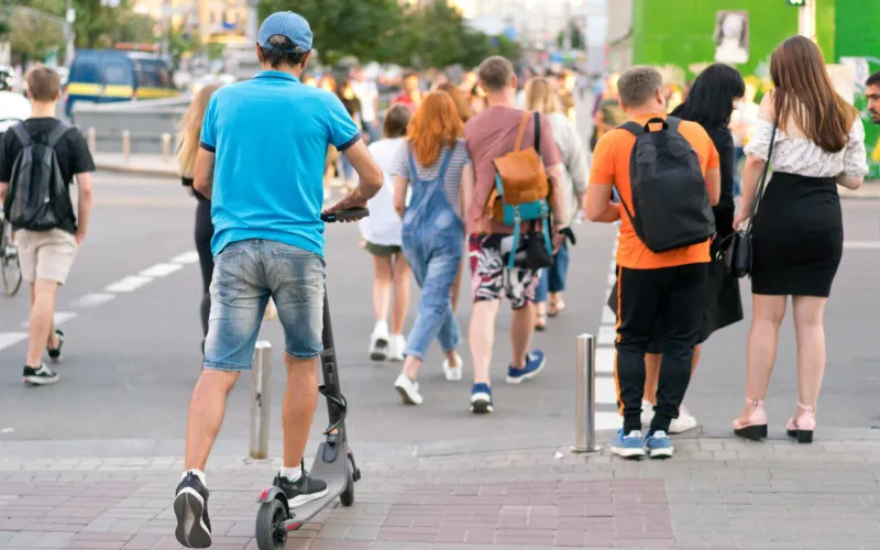 Scooter-Fahrer am Gehsteig