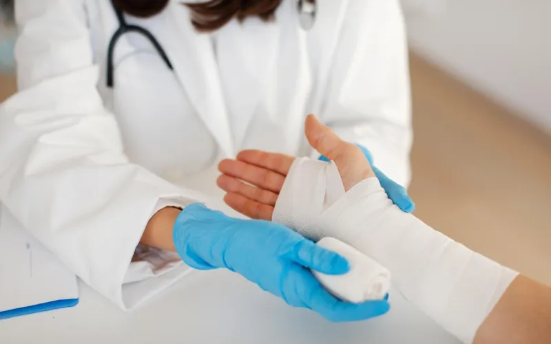 Ärztin verbindet Hand