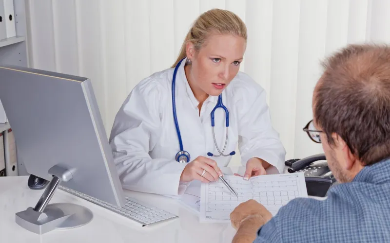 Ärztin mit Stethoskop spricht mit Patienten