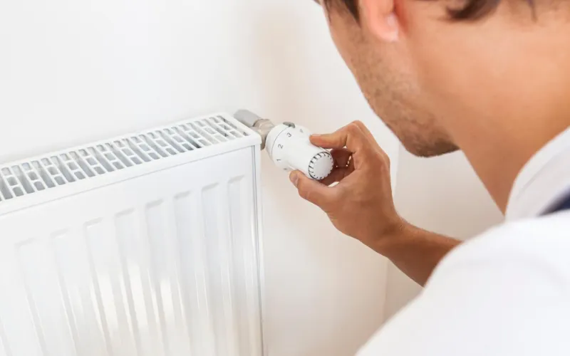 Mann dreht Temperatur zurück