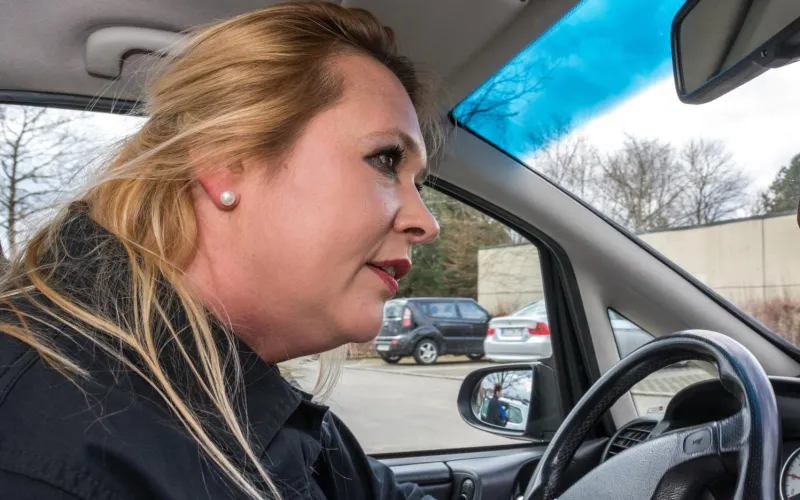 Frau am Steuer eines Autos sucht Parkplatz 