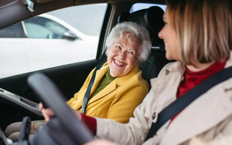 Frau fährt Seniorin zum Arzt