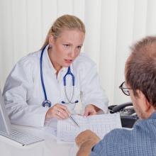 Ärztin mit Stethoskop spricht mit Patienten